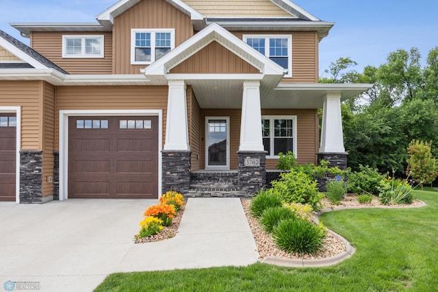 3702 Houkom Dr E, Fargo, ND 58078 - craftsman house featuring a porch, stone siding, an attached garage, concrete driveway, and board and batten siding