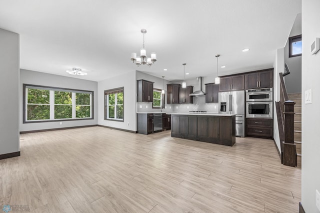 3702 Houkom Dr E, Fargo, ND 58078 - kitchen featuring stainless steel appliances, wall chimney exhaust hood, light countertops, dark brown cabinetry, and open floor plan