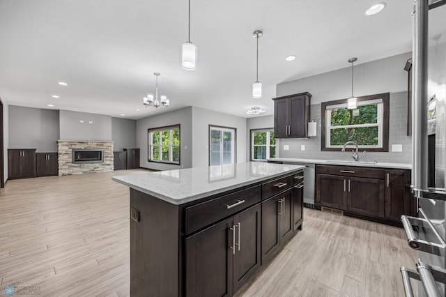 3702 Houkom Dr E, Fargo, ND 58078 - kitchen featuring light wood finished floors, tasteful backsplash, a kitchen island, a fireplace, and recessed lighting