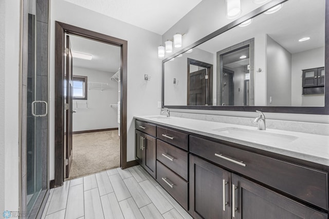 3702 Houkom Dr E, Fargo, ND 58078 - full bathroom featuring double vanity, a spacious closet, and a shower stall