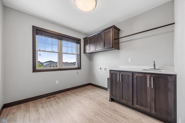 3702 Houkom Dr E, Fargo, ND 58078 - laundry area featuring light wood-type flooring, cabinet space, and hookup for a washing machine