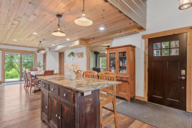 2565 Highland Rd, Minnetrista, MN 55359 - kitchen featuring a wood stove, a kitchen breakfast bar, hardwood / wood-style flooring, wood ceiling, and decorative light fixtures