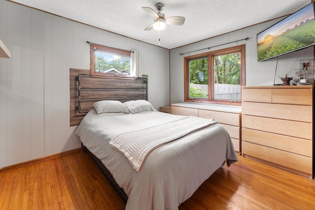 19172 Front Blvd NE, East Bethel, MN 55092 - bedroom with multiple windows, light wood-style flooring, a textured ceiling, and ceiling fan