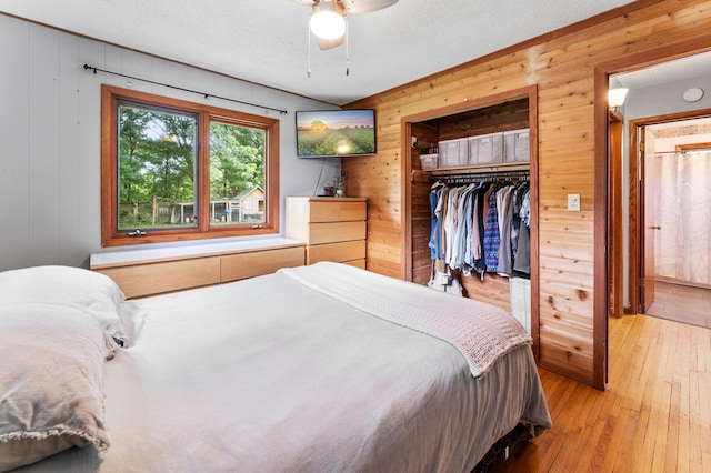 19172 Front Blvd NE, East Bethel, MN 55092 - bedroom with wood walls, light wood-style floors, a closet, a textured ceiling, and a ceiling fan