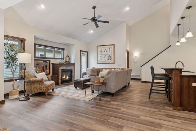 98 Tribute Ave, Hudson, WI 54016 - living room with a ceiling fan, a glass covered fireplace, wood finished floors, high vaulted ceiling, and recessed lighting