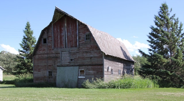 24195 Center St E, Mayfield Twp, MN 56701 - view of home's exterior featuring a barn, an outbuilding, a yard, and a gambrel roof