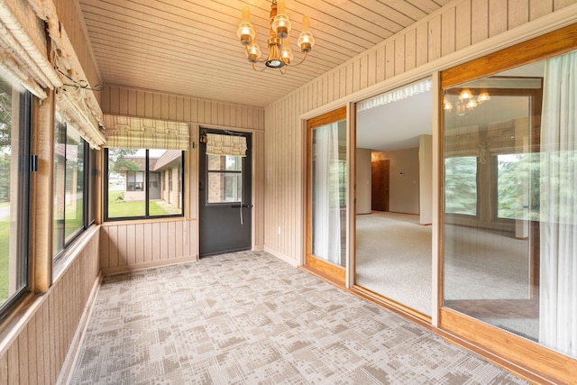 1200 18th Ave NW Unit 132, Austin, MN 55912 - unfurnished sunroom with a chandelier, plenty of natural light, wooden ceiling, and wooden walls