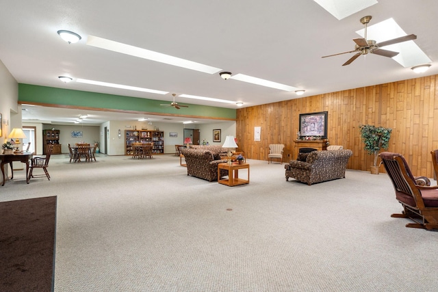 1200 18th Ave NW Unit 132, Austin, MN 55912 - carpeted living area with wood walls, a ceiling fan, and a skylight