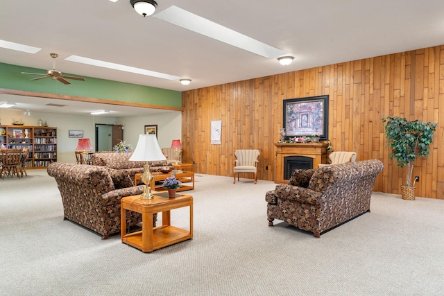 1200 18th Ave NW Unit 132, Austin, MN 55912 - carpeted living room with wood walls, a fireplace, ceiling fan, and a skylight