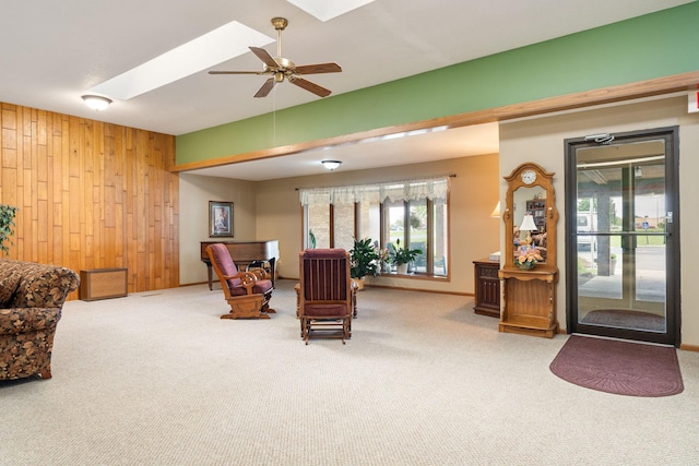 1200 18th Ave NW Unit 132, Austin, MN 55912 - living area featuring wooden walls, carpet flooring, a skylight, and a ceiling fan
