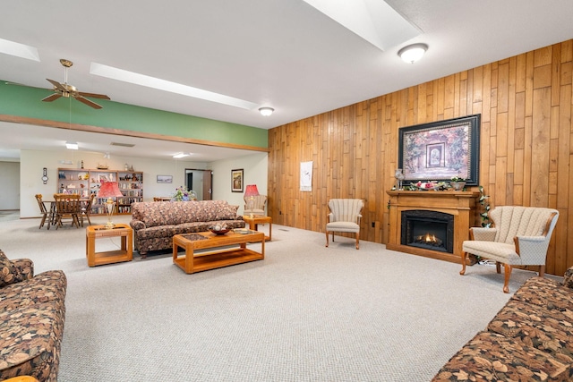 1200 18th Ave NW Unit 132, Austin, MN 55912 - living room with a skylight, wooden walls, carpet flooring, and a warm lit fireplace