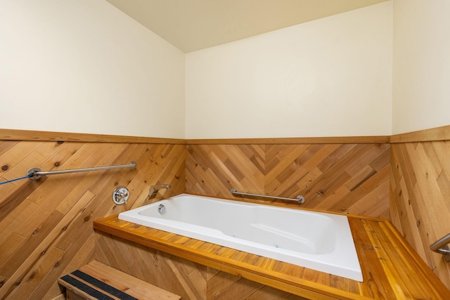 1200 18th Ave NW Unit 132, Austin, MN 55912 - bathroom featuring a whirlpool tub, a wainscoted wall, and wooden walls