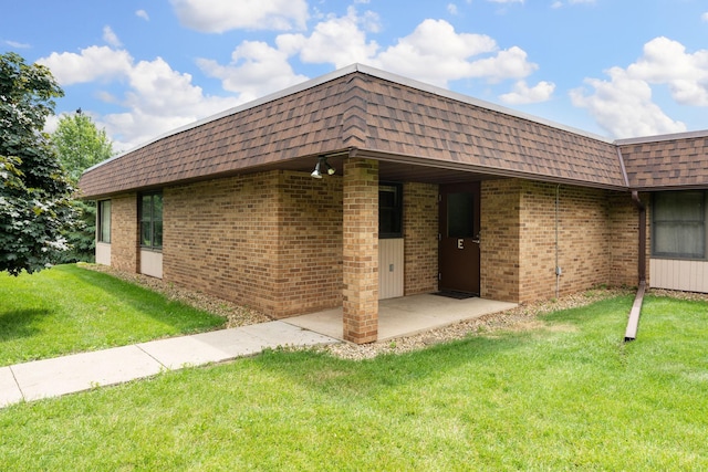 1200 18th Ave NW Unit 132, Austin, MN 55912 - exterior space featuring mansard roof, a shingled roof, and a yard
