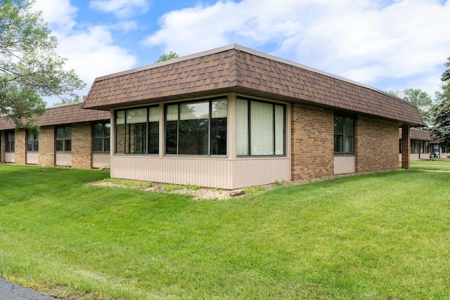 1200 18th Ave NW Unit 132, Austin, MN 55912 - view of side of property with mansard roof, brick siding, and a yard