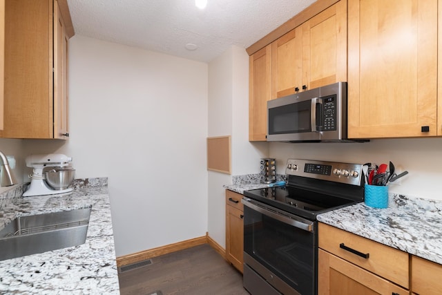 728 Linn St N, Prescott, WI 54021 - kitchen with stainless steel appliances, dark wood-type flooring, a textured ceiling, light stone countertops, and light brown cabinetry