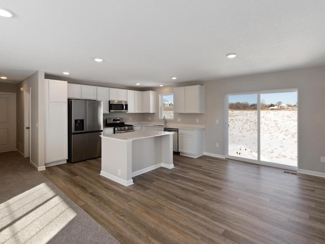 6706 376th St, North Branch, MN 55056 - kitchen with stainless steel appliances, white cabinets, dark wood-style flooring, light countertops, and a kitchen island