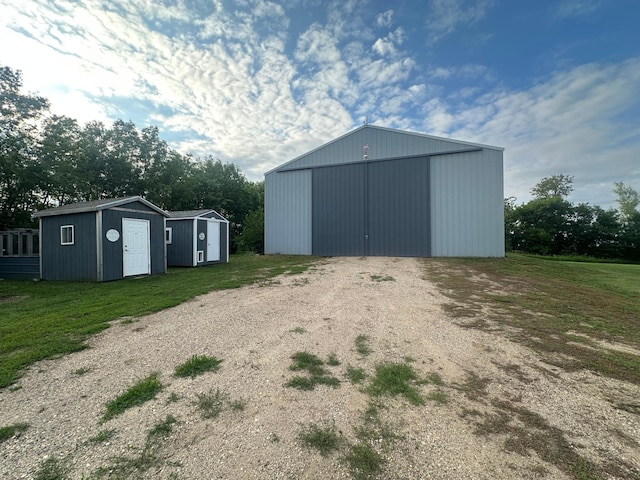 1865 180th St, Norman Twp, MN 56220 - view of pole building featuring driveway, a yard, and a storage unit