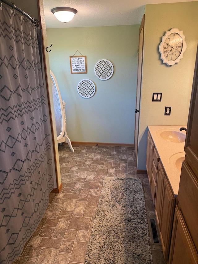 1865 180th St, Norman Twp, MN 56220 - bathroom with double vanity, a shower with shower curtain, and stone finish floors