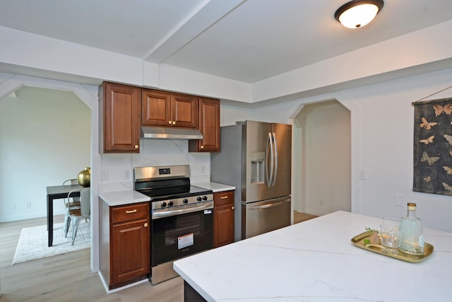 10419 Goldenrod St NW, Coon Rapids, MN 55448 - kitchen with appliances with stainless steel finishes, under cabinet range hood, light countertops, light wood finished floors, and arched walkways