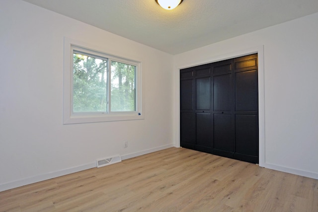 10419 Goldenrod St NW, Coon Rapids, MN 55448 - unfurnished bedroom featuring light wood-style floors and a closet