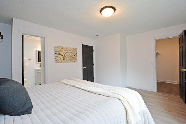 10419 Goldenrod St NW, Coon Rapids, MN 55448 - bedroom featuring wood finished floors, a spacious closet, and connected bathroom
