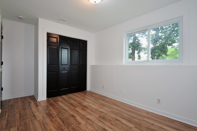 10419 Goldenrod St NW, Coon Rapids, MN 55448 - unfurnished bedroom featuring wood finished floors and a closet