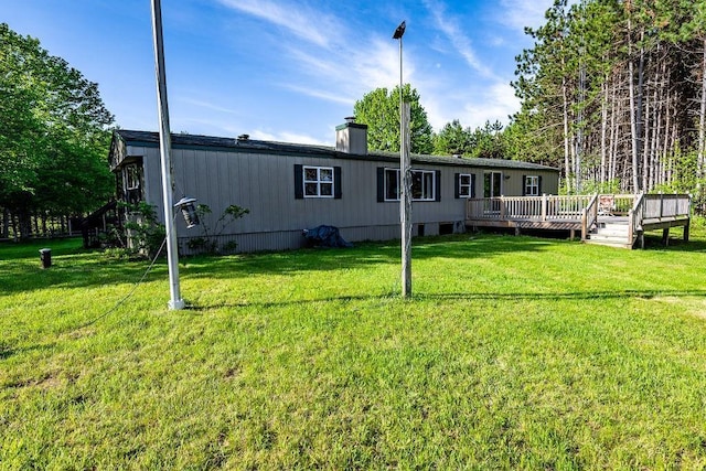 N5172 County Road O, Atlanta Twp, WI 54819 - back of property featuring a wooden deck, a chimney, and a yard