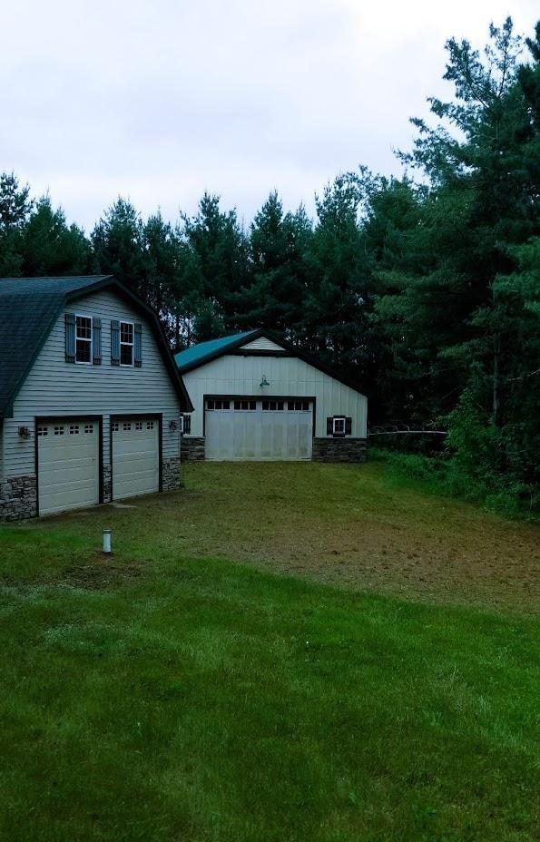 N5172 County Road O, Atlanta Twp, WI 54819 - view of grassy yard with a detached garage and an outbuilding