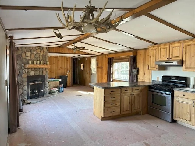 N5172 County Road O, Atlanta Twp, WI 54819 - kitchen with gas stove, under cabinet range hood, dark countertops, a peninsula, and a stone fireplace