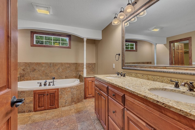 213 2nd St N, Cold Spring, MN 56320 - full bath featuring double vanity, a bath, stone finish floors, and a textured ceiling