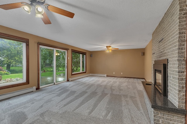 213 2nd St N, Cold Spring, MN 56320 - unfurnished living room with ceiling fan, a baseboard heating unit, healthy amount of natural light, a fireplace, and a textured ceiling