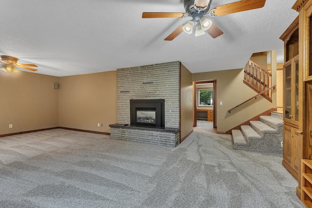 213 2nd St N, Cold Spring, MN 56320 - unfurnished living room featuring a ceiling fan, carpet floors, stairs, a textured ceiling, and a brick fireplace