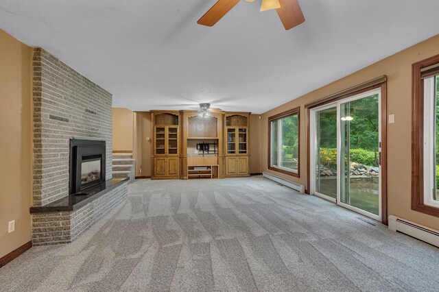 213 2nd St N, Cold Spring, MN 56320 - unfurnished living room with a ceiling fan, baseboard heating, carpet floors, and a brick fireplace