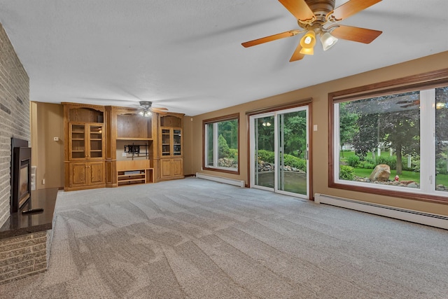 213 2nd St N, Cold Spring, MN 56320 - unfurnished living room featuring a baseboard heating unit, ceiling fan, a fireplace, carpet flooring, and brick wall