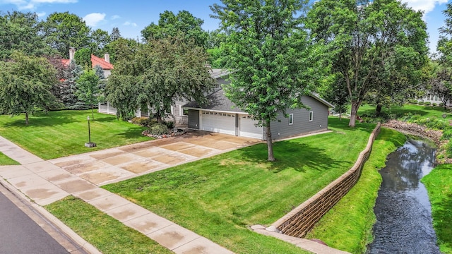213 2nd St N, Cold Spring, MN 56320 - view of property hidden behind natural elements featuring concrete driveway, a front yard, a water view, and a garage