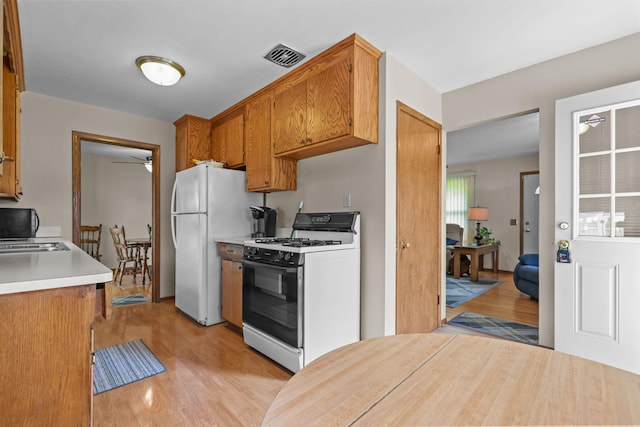 5913 Zenith Ave N, Brooklyn Center, MN 55429 - kitchen featuring range with gas cooktop, ceiling fan, light wood-type flooring, light countertops, and brown cabinetry
