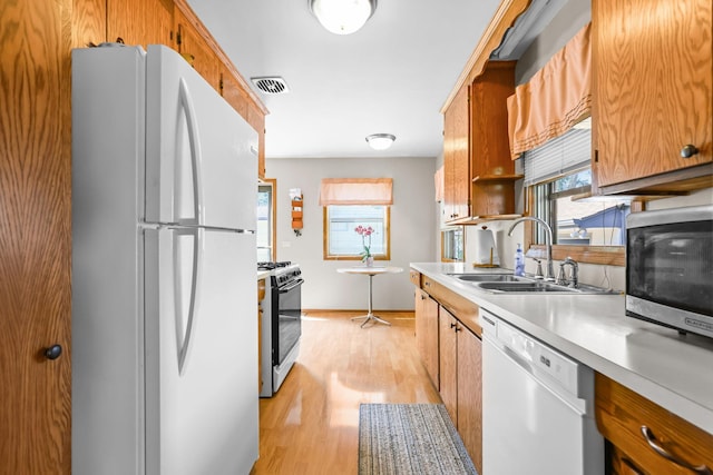 5913 Zenith Ave N, Brooklyn Center, MN 55429 - kitchen with white appliances, light countertops, light wood finished floors, and brown cabinets