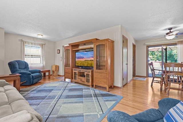 5913 Zenith Ave N, Brooklyn Center, MN 55429 - living area featuring a textured ceiling, light wood-style floors, and a ceiling fan