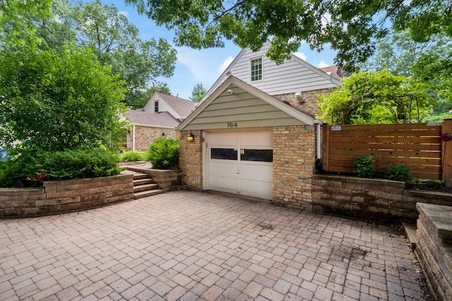 704 58th St, Minneapolis, MN 55417 - view of front of house with an attached garage, decorative driveway, and brick siding