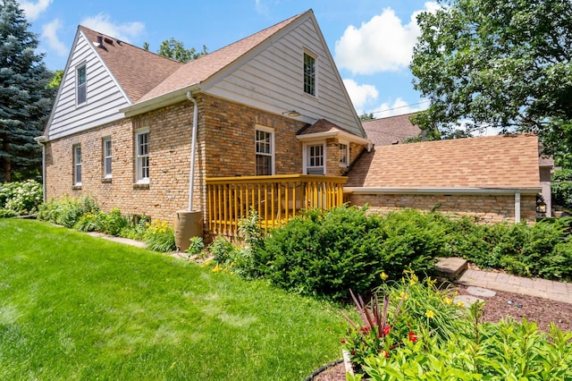 704 58th St, Minneapolis, MN 55417 - view of home's exterior featuring a yard, roof with shingles, brick siding, and a deck