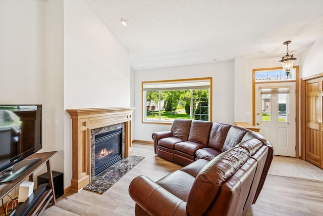 13936 54th Ave N Unit 2, Plymouth, MN 55446 - living area with a premium fireplace, a textured ceiling, light wood finished floors, and lofted ceiling