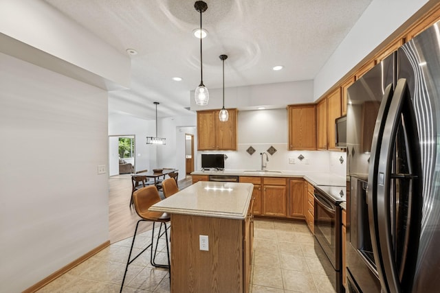 13936 54th Ave N Unit 2, Plymouth, MN 55446 - kitchen featuring appliances with stainless steel finishes, a kitchen island, a kitchen breakfast bar, light countertops, and hanging light fixtures