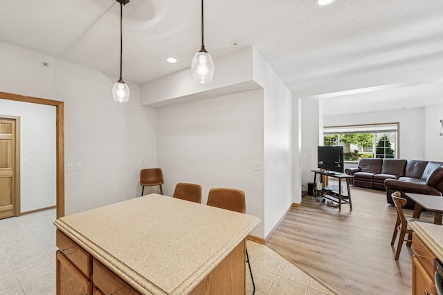 13936 54th Ave N Unit 2, Plymouth, MN 55446 - kitchen with a breakfast bar, light countertops, brown cabinets, hanging light fixtures, and recessed lighting