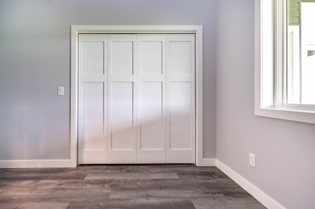 41565 Thunder Rd, Clitherall, MN 56524 - unfurnished bedroom featuring a closet and dark wood-style flooring