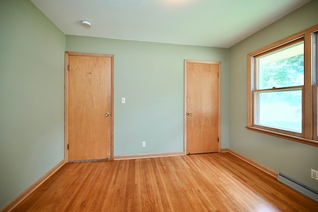 731 Clarks Ln, Winona, MN 55987 - unfurnished bedroom featuring baseboard heating and light wood-type flooring