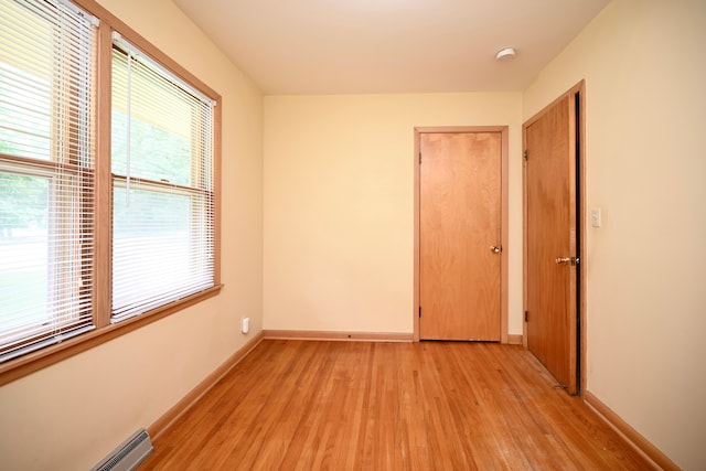 731 Clarks Ln, Winona, MN 55987 - spare room featuring light wood-style flooring, a smoke detector, and a baseboard heating unit