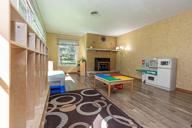 1007 Ruby St NW, Alexandria, MN 56308 - recreation room featuring wood finished floors and a brick fireplace