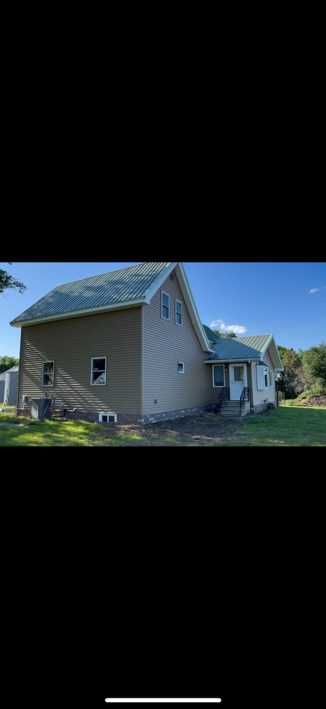 74194 415th St, South Branch Twp, MN 56081 - view of side of property featuring a standing seam roof, a metal roof, entry steps, and a yard