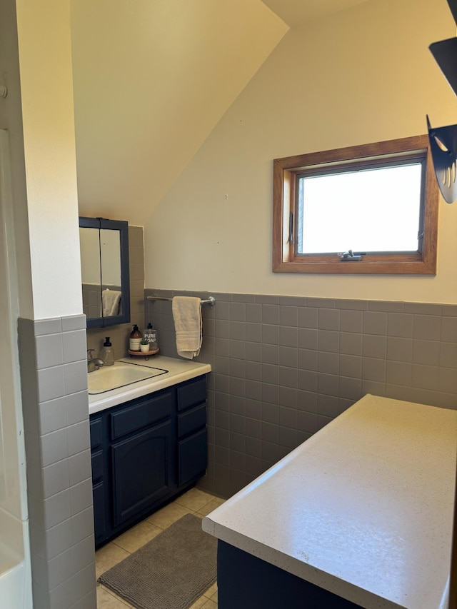 74194 415th St, South Branch Twp, MN 56081 - bathroom featuring tile walls, vanity, lofted ceiling, tile patterned flooring, and wainscoting