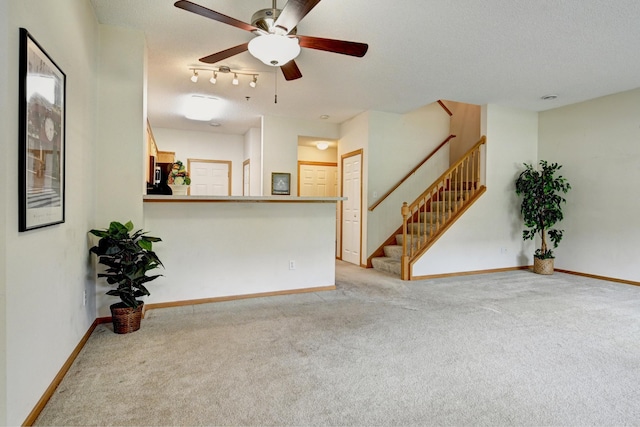 11307 Chisholm Cir NE Unit C, Blaine, MN 55449 - unfurnished living room with light colored carpet, ceiling fan, stairway, and a textured ceiling